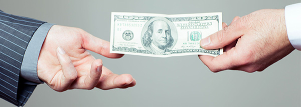 Hand handing over borrowed money to another hand Hand handing over borrowed money to another hand